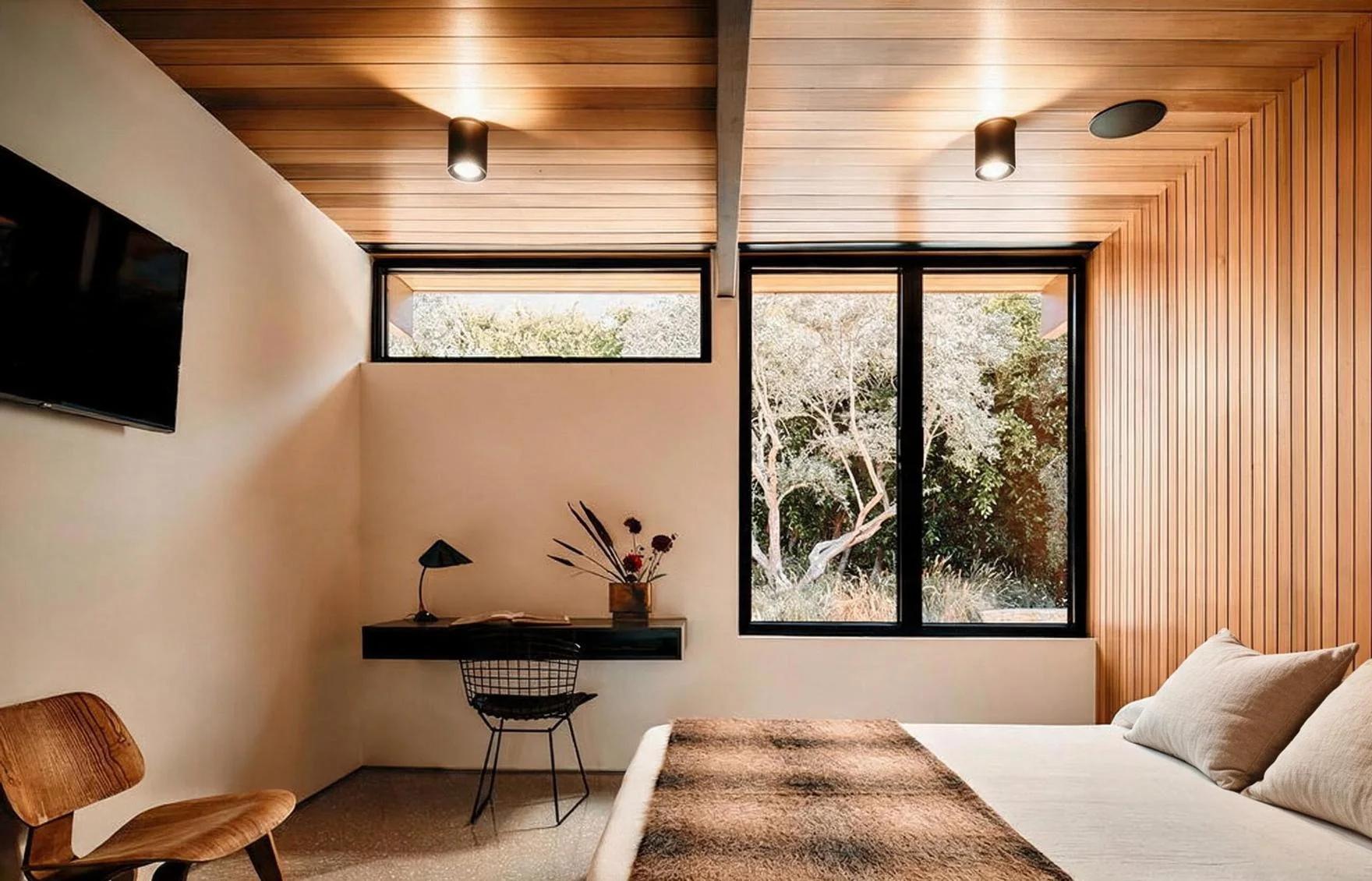 A bedroom desk under a clerestory window, the oaks outside.