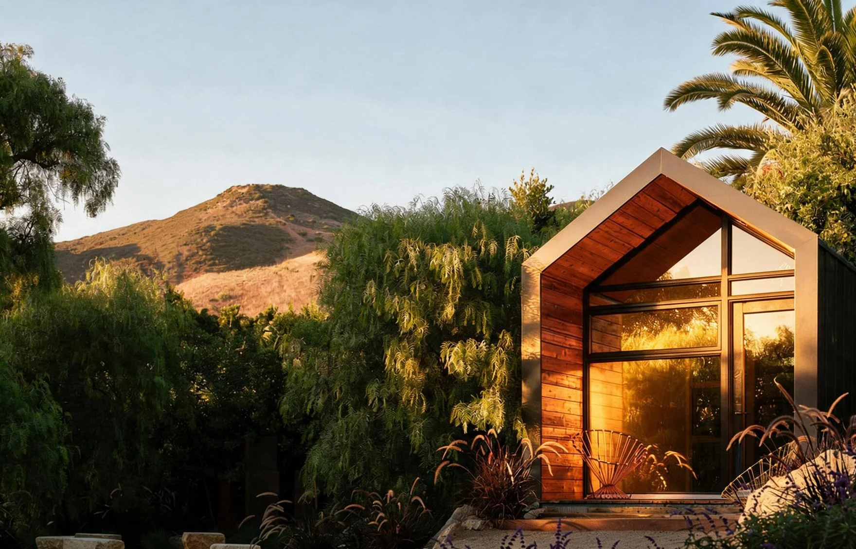 The guest house, a timber A-frame against the hills.