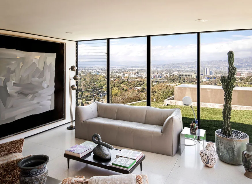 The living room in its glass corner, the city beyond.