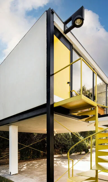 The yellow spiral stair against the white frame.