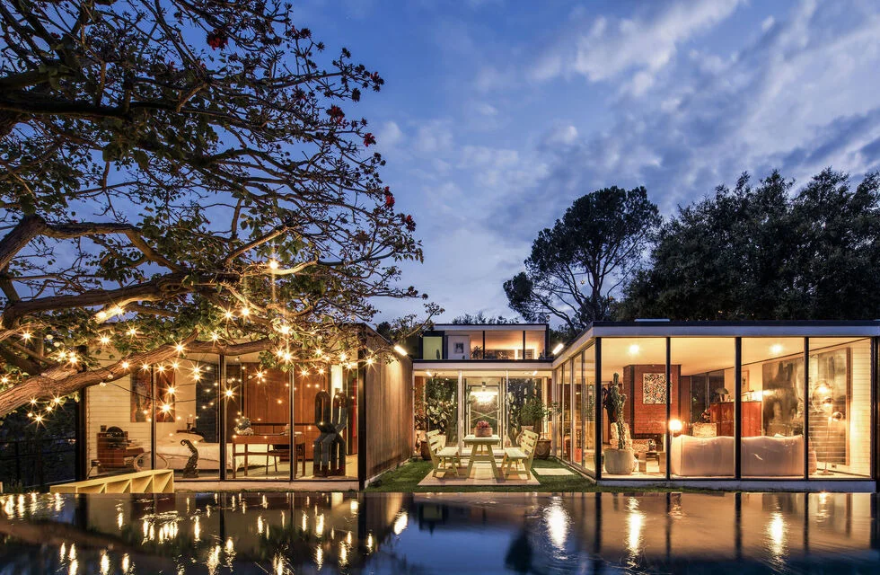 The house at night, lit over the pool.