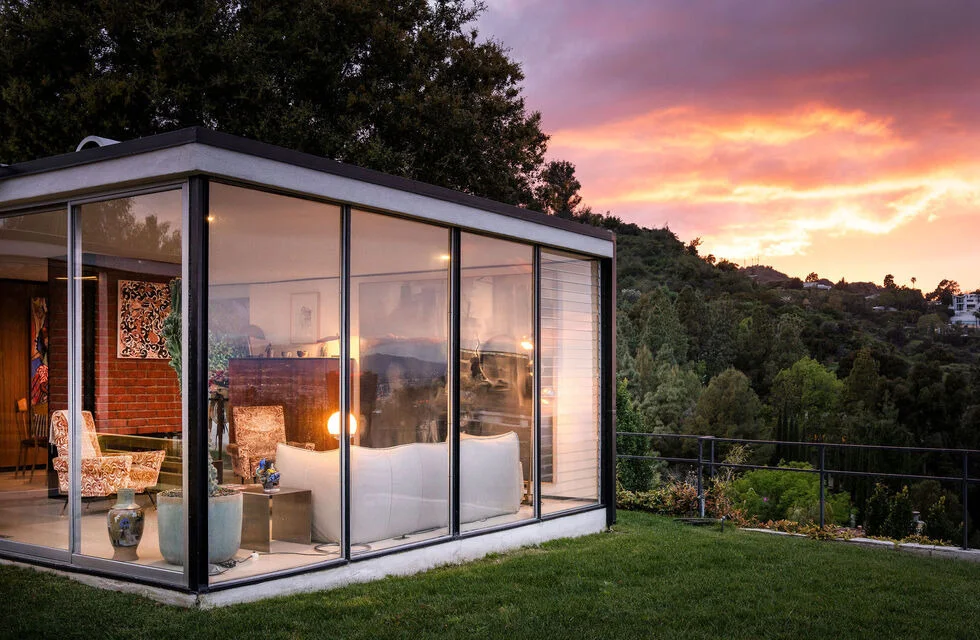 A glass bedroom at dusk.