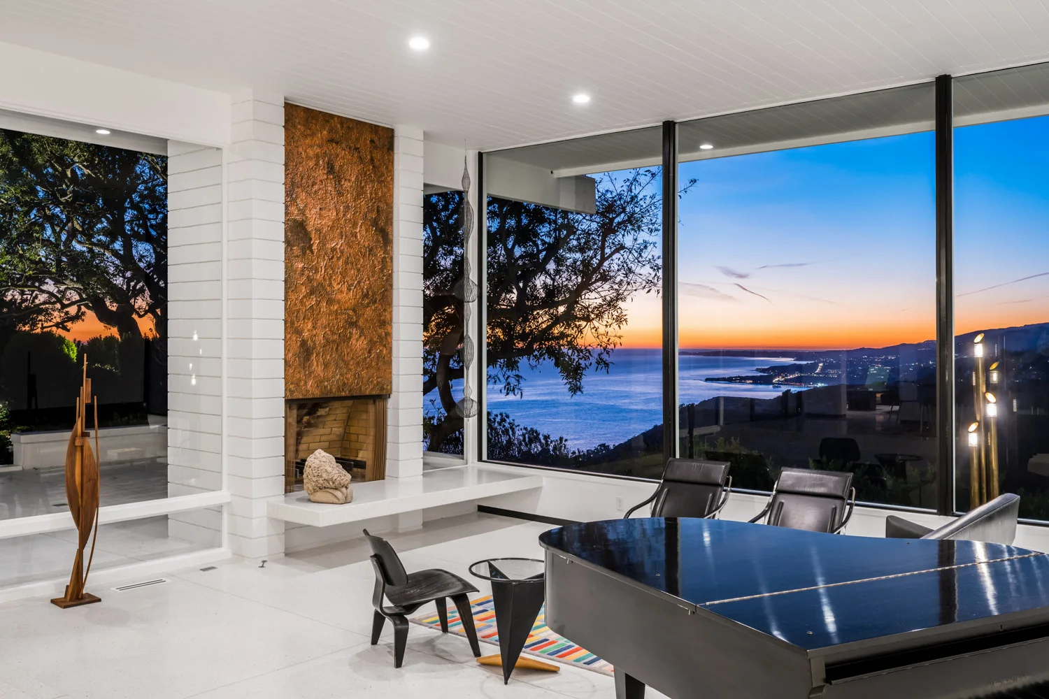 The living room at sunset: the fireplace lit, the last light on the ocean.