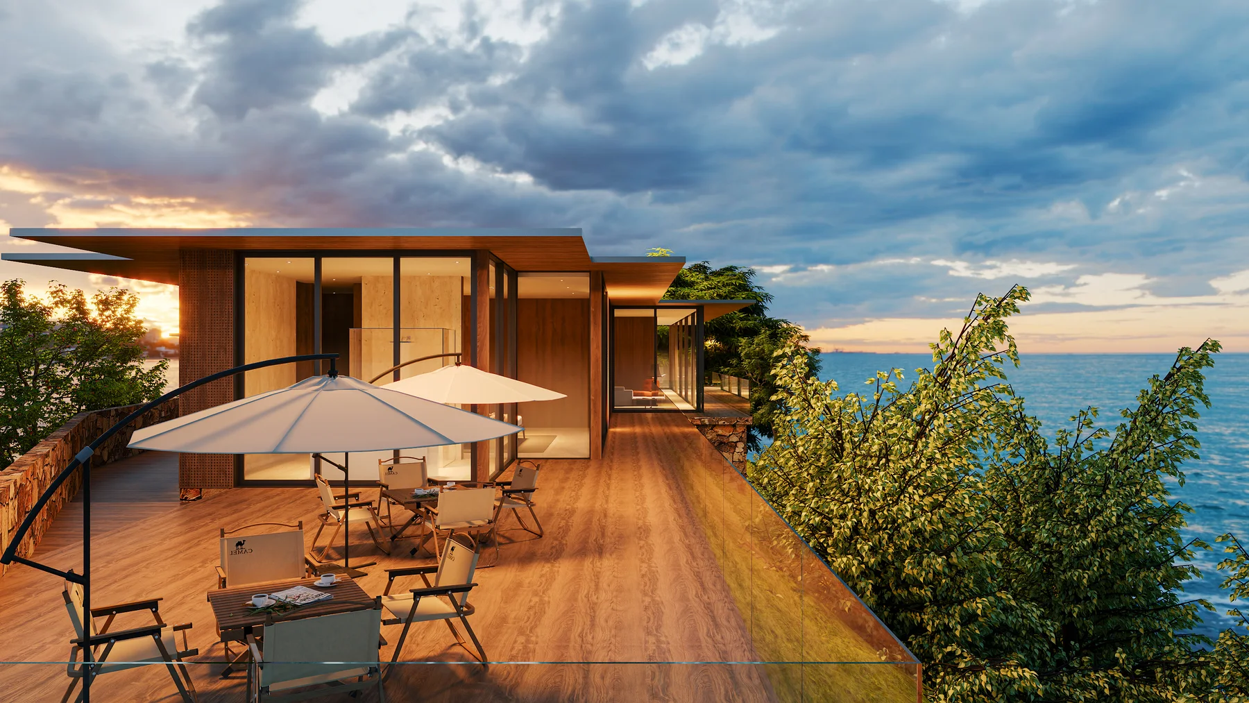 The terrace and its dining table under an umbrella, sunset on the water.